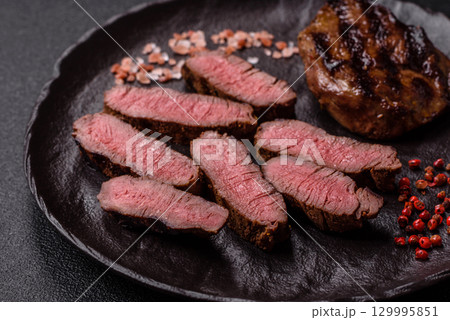 Grilled beef steak meat with salt and pepper. Beef steak grilled on a barbecue Grilled beef steak meat with salt and pepper. Beef steak grilled on a barbecue 129995851