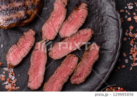 Grilled beef steak meat with salt and pepper. Beef steak grilled on a barbecue 129995856