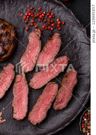 Grilled beef steak meat with salt and pepper. Beef steak grilled on a barbecue 129995857