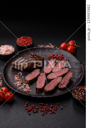 Grilled beef steak meat with salt and pepper. Beef steak grilled on a barbecue 129995862