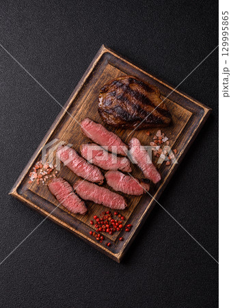 Grilled beef steak meat with salt and pepper. Beef steak grilled on a barbecue Grilled beef steak meat with salt and pepper. Beef steak grilled on a barbecue 129995865