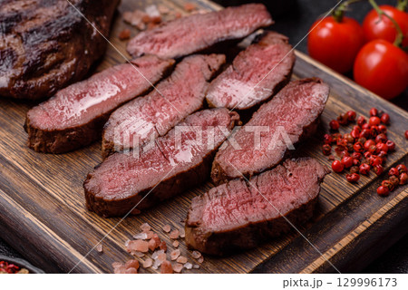 Grilled beef steak meat with salt and pepper. Beef steak grilled on a barbecue Grilled beef steak meat with salt and pepper. Beef steak grilled on a barbecue 129996173