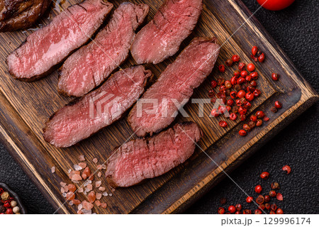 Grilled beef steak meat with salt and pepper. Beef steak grilled on a barbecue 129996174