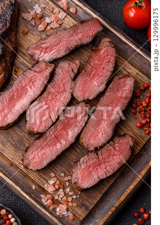 Grilled beef steak meat with salt and pepper. Beef steak grilled on a barbecue Grilled beef steak meat with salt and pepper. Beef steak grilled on a barbecue 129996175