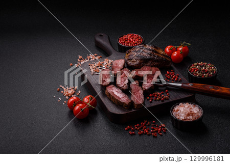 Grilled beef steak meat with salt and pepper. Beef steak grilled on a barbecue 129996181