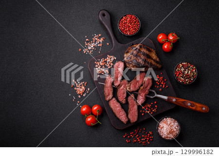 Grilled beef steak meat with salt and pepper. Beef steak grilled on a barbecue Grilled beef steak meat with salt and pepper. Beef steak grilled on a barbecue 129996182