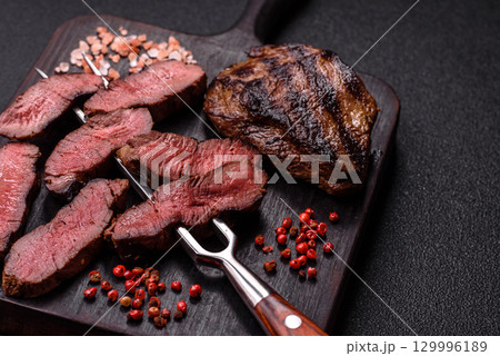 Grilled beef steak meat with salt and pepper. Beef steak grilled on a barbecue Grilled beef steak meat with salt and pepper. Beef steak grilled on a barbecue 129996189