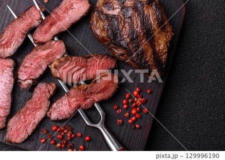 Grilled beef steak meat with salt and pepper. Beef steak grilled on a barbecue Grilled beef steak meat with salt and pepper. Beef steak grilled on a barbecue 129996190