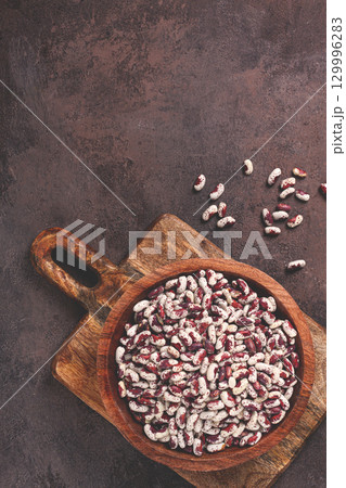 variegated beans, red with white spots, raw in a wooden bowl, top view, no people, 129996283