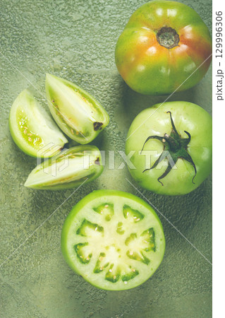 green tomatoes, sliced on the table, unripe tomatoes, raw , selective focus, no people, 129996306