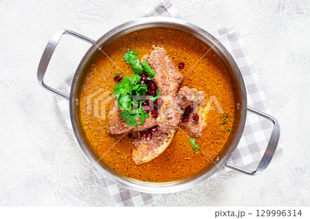 fesenjan, an Iranian dish, stewed chicken, in a nut-pomegranate sauce, in a saucepan,light background, homemade, no people, fesenjan, an Iranian dish, stewed chicken, in a nut-pomegranate sauce, in a saucepan,light background, homemade, no people, 129996314