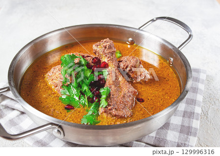 fesenjan, an Iranian dish, stewed chicken, in a nut-pomegranate sauce, in a saucepan,light background, homemade, no people, 129996316