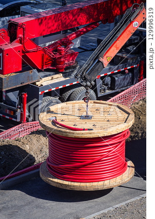 Big red cable coil, rises for installation at the city construction site, no people 129996319