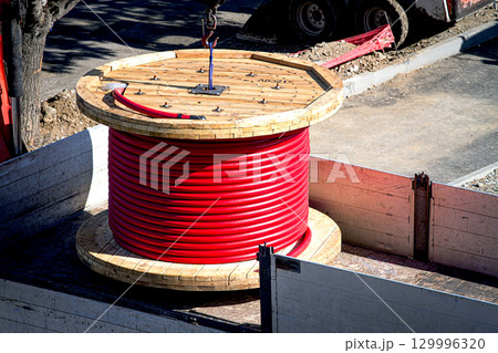 Big red cable coil, rises for installation at the city construction site, no people Big red cable coil, rises for installation at the city construction site, no people 129996320