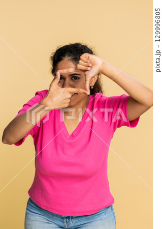Indian woman framing photo with hands, creatively imagining perfect photography or blogging idea Indian woman framing photo with hands, creatively imagining perfect photography or blogging idea 129996805