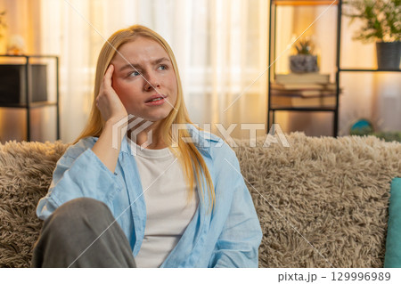 Young woman massaging head at home, migraine tension, closed eyes, sofa fatigue, stressful moment Young woman massaging head at home, migraine tension, closed eyes, sofa fatigue, stressful moment 129996989