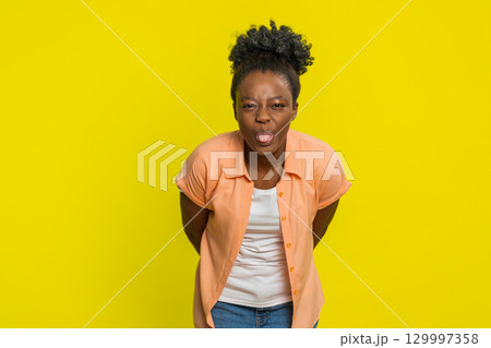 Cheerful funny bully woman showing tongue making silly faces, fooling around joking teasing 129997358