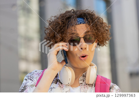 Happy young man tourist having remote conversation communicate speaking by smartphone with friends 129997363
