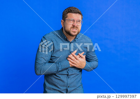 Stressed ill sick man suffers from tension holding chest with heart pain attack risk of stroke Stressed ill sick man suffers from tension holding chest with heart pain attack risk of stroke 129997397