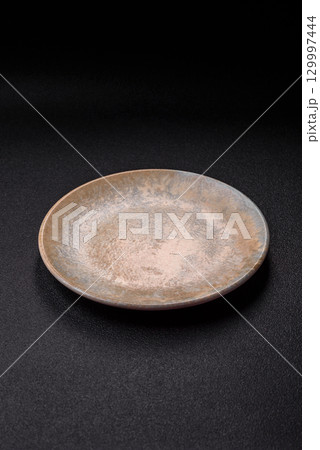 Empty round black plate for food, kitchen utensils on dining table. Empty plate Empty round black plate for food, kitchen utensils on dining table. Empty plate 129997444