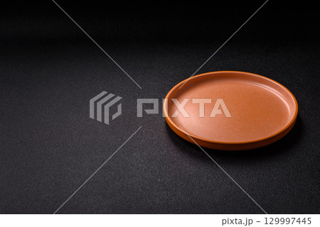 Empty round black plate for food, kitchen utensils on dining table. Empty plate Empty round black plate for food, kitchen utensils on dining table. Empty plate 129997445