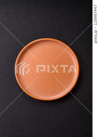 Empty round black plate for food, kitchen utensils on dining table. Empty plate 129997447