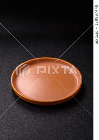 Empty round black plate for food, kitchen utensils on dining table. Empty plate Empty round black plate for food, kitchen utensils on dining table. Empty plate 129997448
