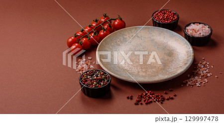 Empty round black plate for food, kitchen utensils on dining table. Empty plate Empty round black plate for food, kitchen utensils on dining table. Empty plate 129997478