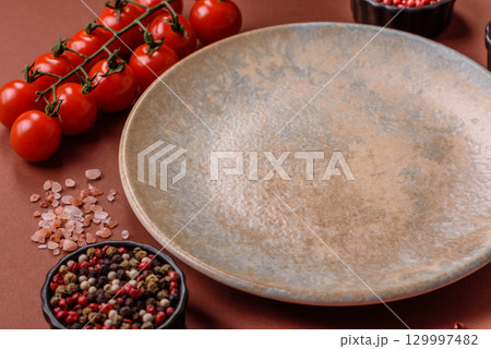 Empty round black plate for food, kitchen utensils on dining table. Empty plate 129997482