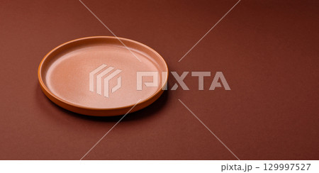 Empty round black plate for food, kitchen utensils on dining table. Empty plate Empty round black plate for food, kitchen utensils on dining table. Empty plate 129997527