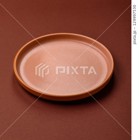 Empty round black plate for food, kitchen utensils on dining table. Empty plate Empty round black plate for food, kitchen utensils on dining table. Empty plate 129997530