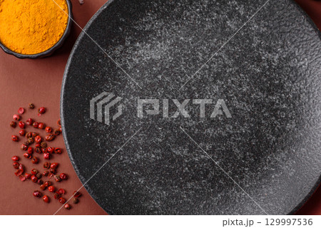 Empty round black plate for food, kitchen utensils on dining table. Empty plate 129997536