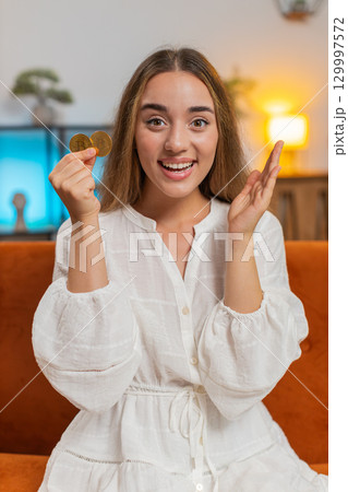 Portrait of happy young woman holding two gold BTC coins at home successful developer programmer Portrait of happy young woman holding two gold BTC coins at home successful developer programmer 129997572
