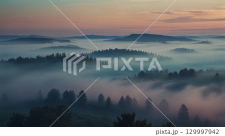 A photorealistic view of a misty valley at dawn, with forests and individual trees shrouded in fog. The soft blue and pink tones create a tranquil predawn atmosphere with reduced visibility. 129997942