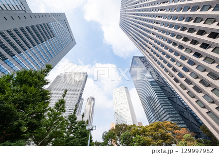 街路樹と高層ビルを見上げるオフィス街の風景 129997982
