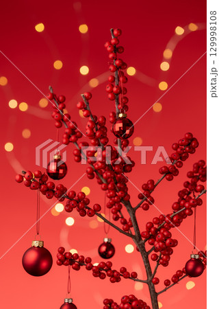 Red Ilex Branch With Christmas Baubles And Lights 129998108