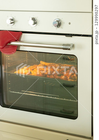 Pizza with pepperoni and sausage cheese is baked in the oven in kitchen or in family restaurant.  129998297