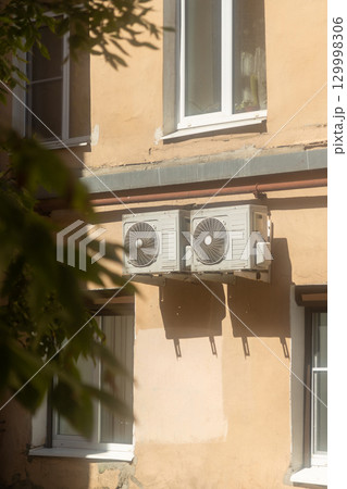 Air conditioners are installed on facade of building. device for comfortable living in hot weather. 129998306
