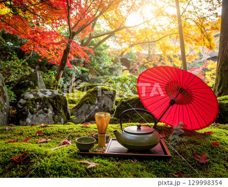 紅葉に包まれた和傘と茶道具 ― 日本庭園の秋の風景 129998354