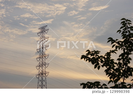 夕焼けに染まる送電線 129998398