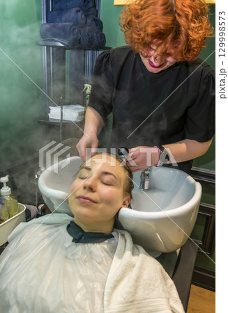 The client is having his head washed in a beauty salon 129998573
