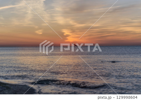 A sunset over a body of water A sunset over a body of water 129998604