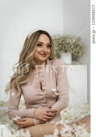 young beautiful blonde girl among feathers young beautiful blonde girl among feathers 129998617