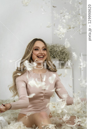 young beautiful blonde girl among feathers young beautiful blonde girl among feathers 129998620