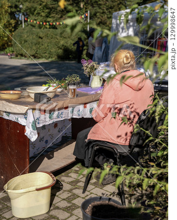 a retired woman sells plants at a city fair a retired woman sells plants at a city fair 129998647