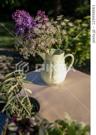 A vase filled with purple flowers on a table A vase filled with purple flowers on a table 129998661