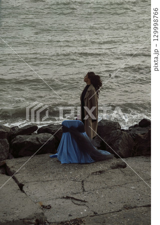 young girl on the seashore around the rocks young girl on the seashore around the rocks 129998766