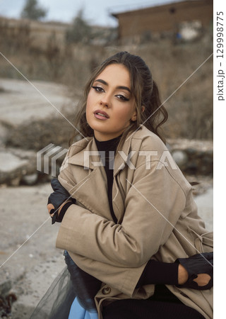 young girl on the seashore around the rocks 129998775