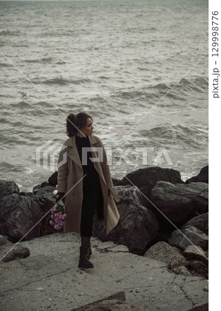 young girl on the seashore around the rocks young girl on the seashore around the rocks 129998776
