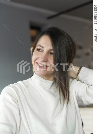 a woman who works in an office sits in front of a window 129998804